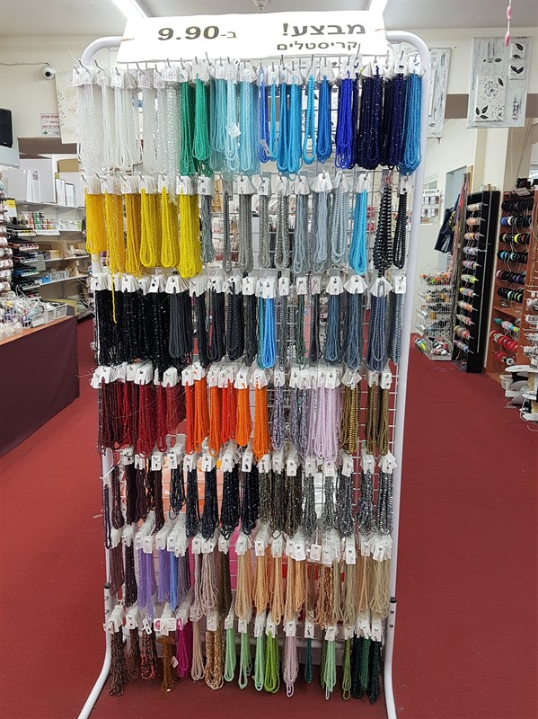 מבחר גדול של חרוזי זכוכית בחנות חרוזים משי. מבחר ענק של חרוזים מכל העולם